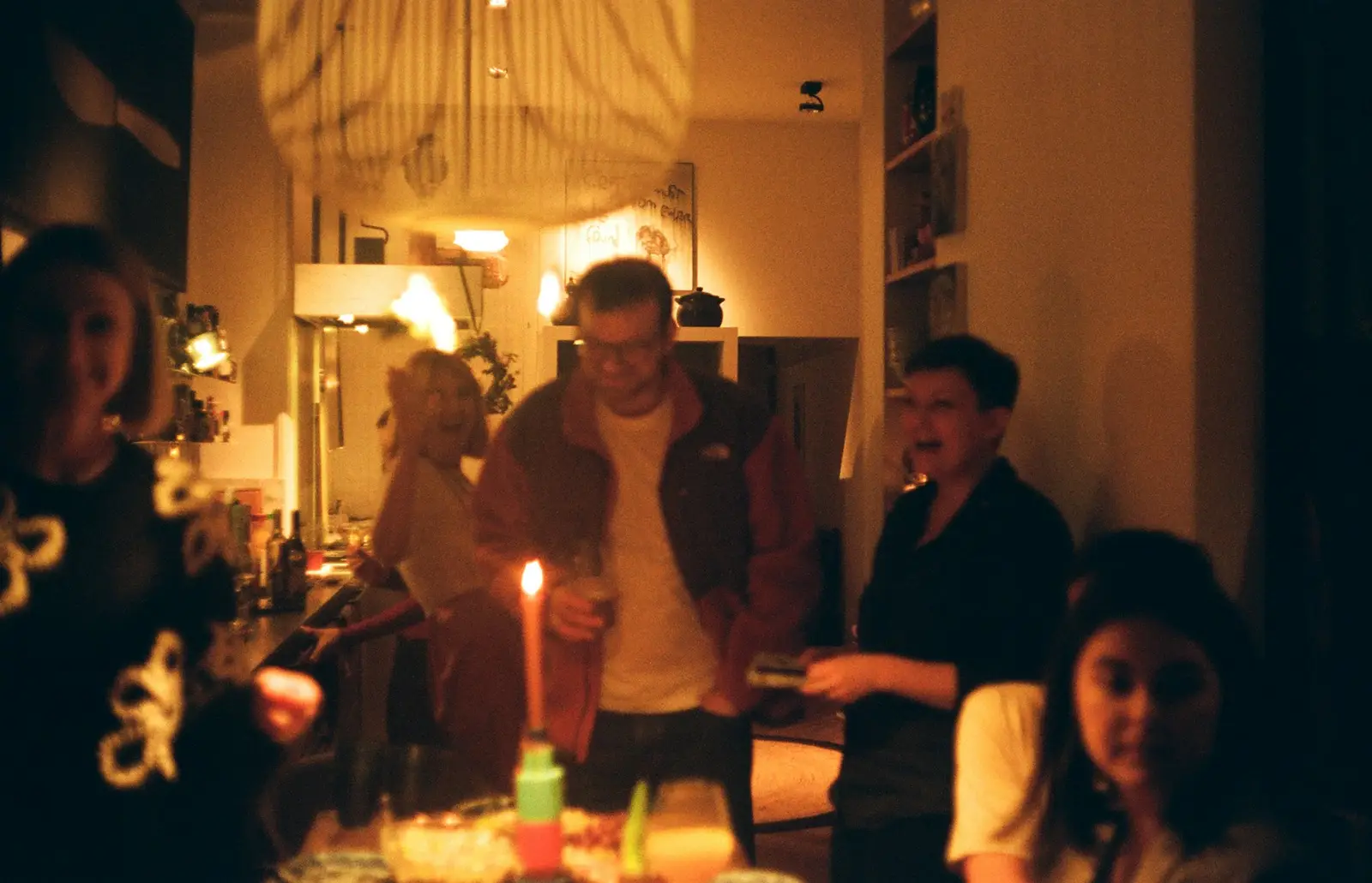 Friends gathered close around a candlelit table
