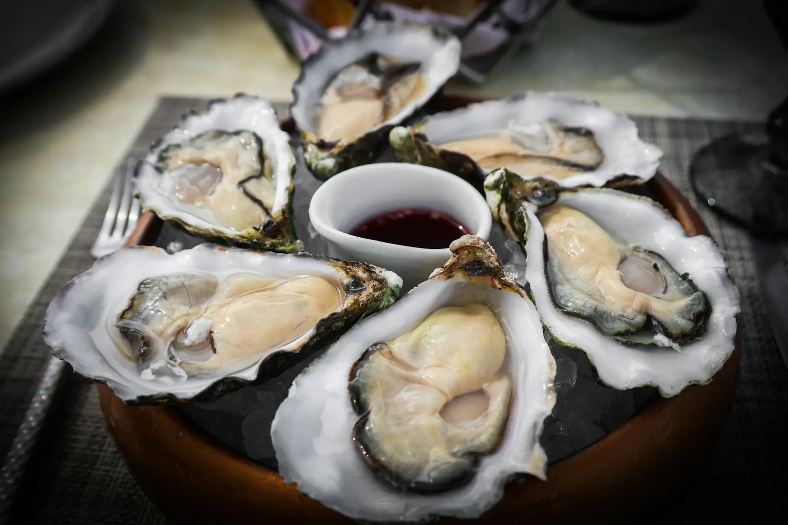 Freshly shucked oysters on crushed ice with a small dish of sauce