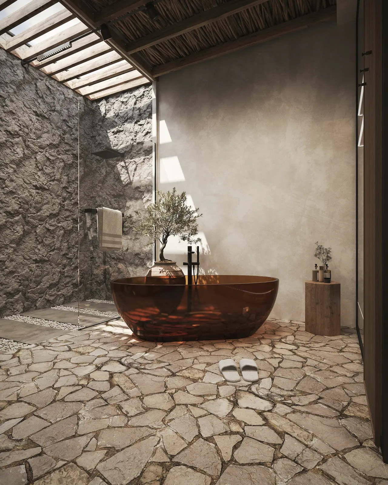 A copper bath on a stone floor beside a rough rock wall, lit from above