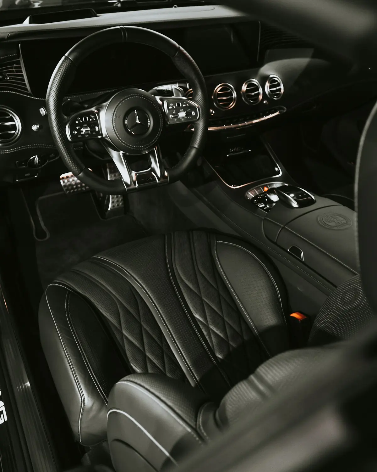 The black leather seats and dashboard of a car, freshly cleaned