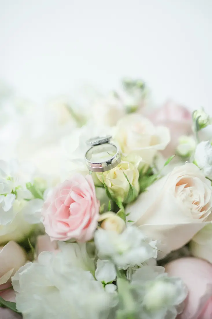 A ring resting on a bouquet of white and pink roses