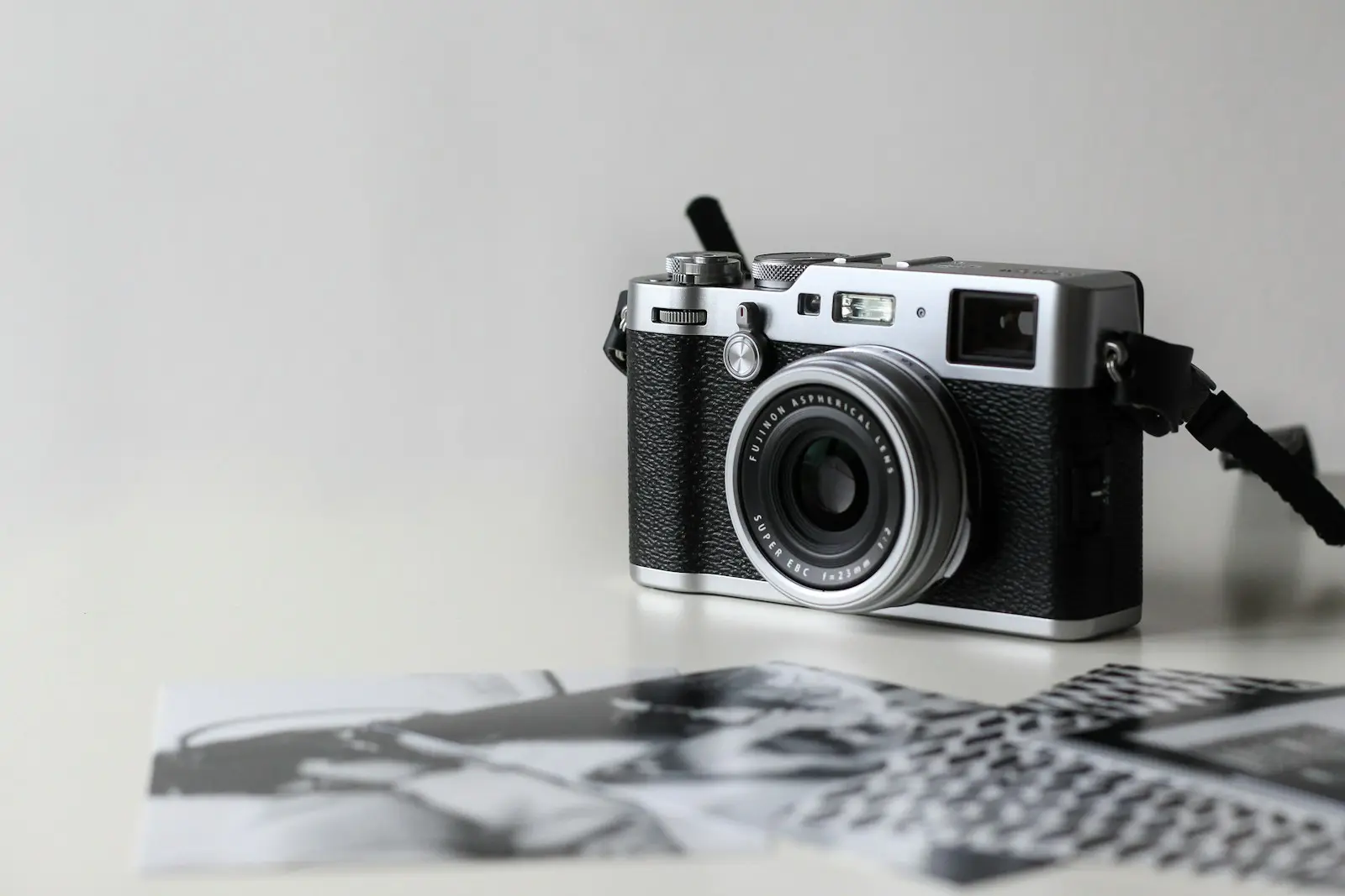 A film camera resting on a spread of printed photographs