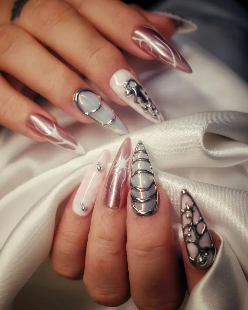 Long stiletto nails in rose chrome with fine black line drawings on four nails
