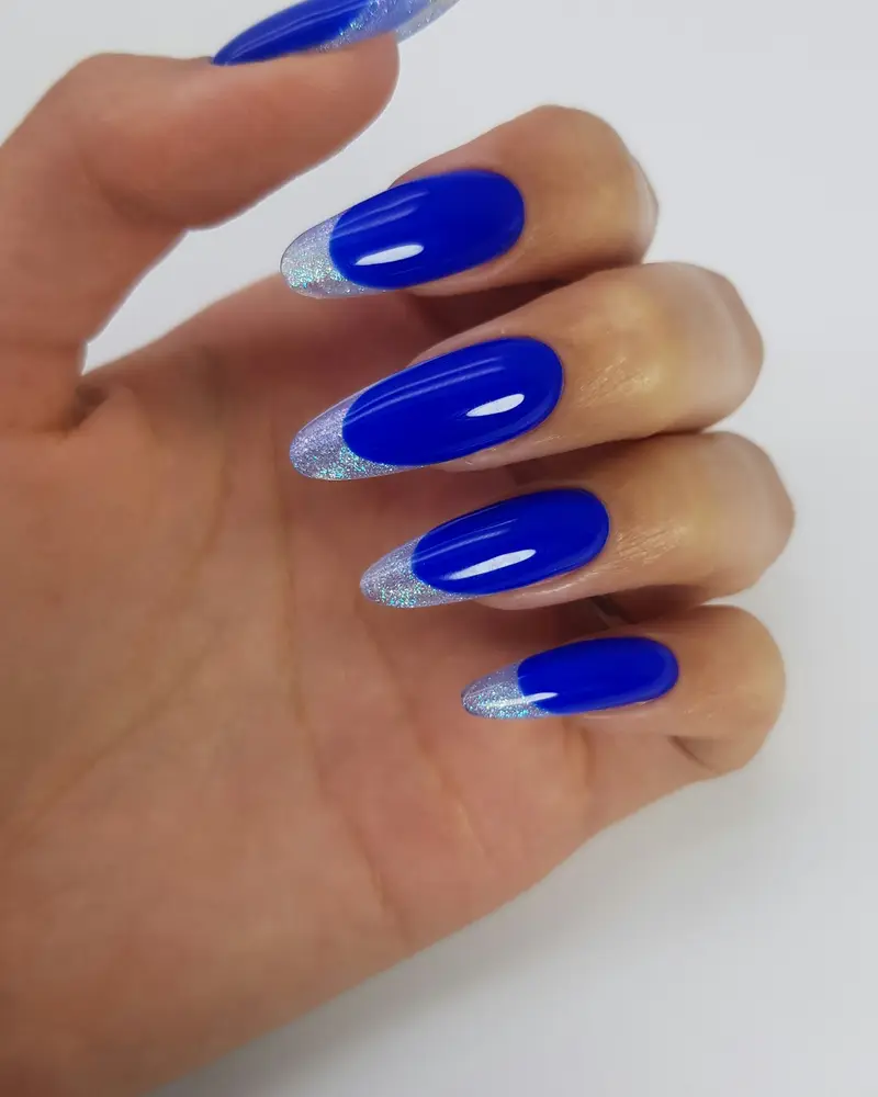 Almond nails in glossy cobalt blue with thin silver french tips