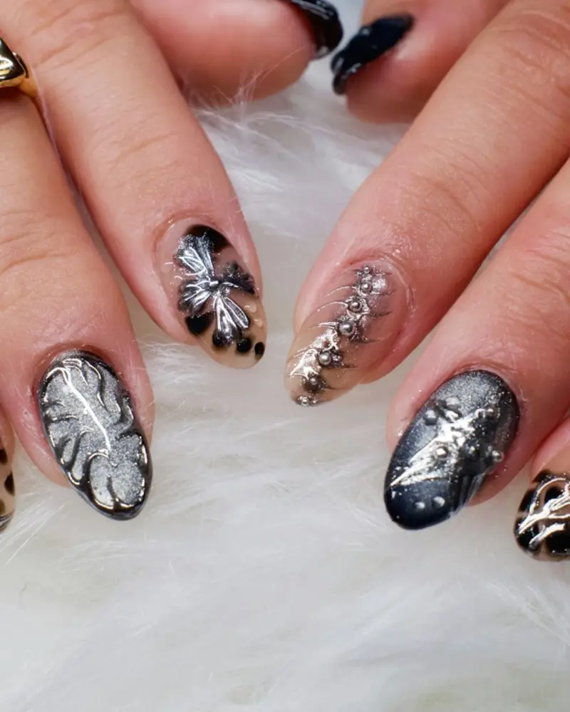 Almond nails with hand-painted leopard spots and silver leaf details