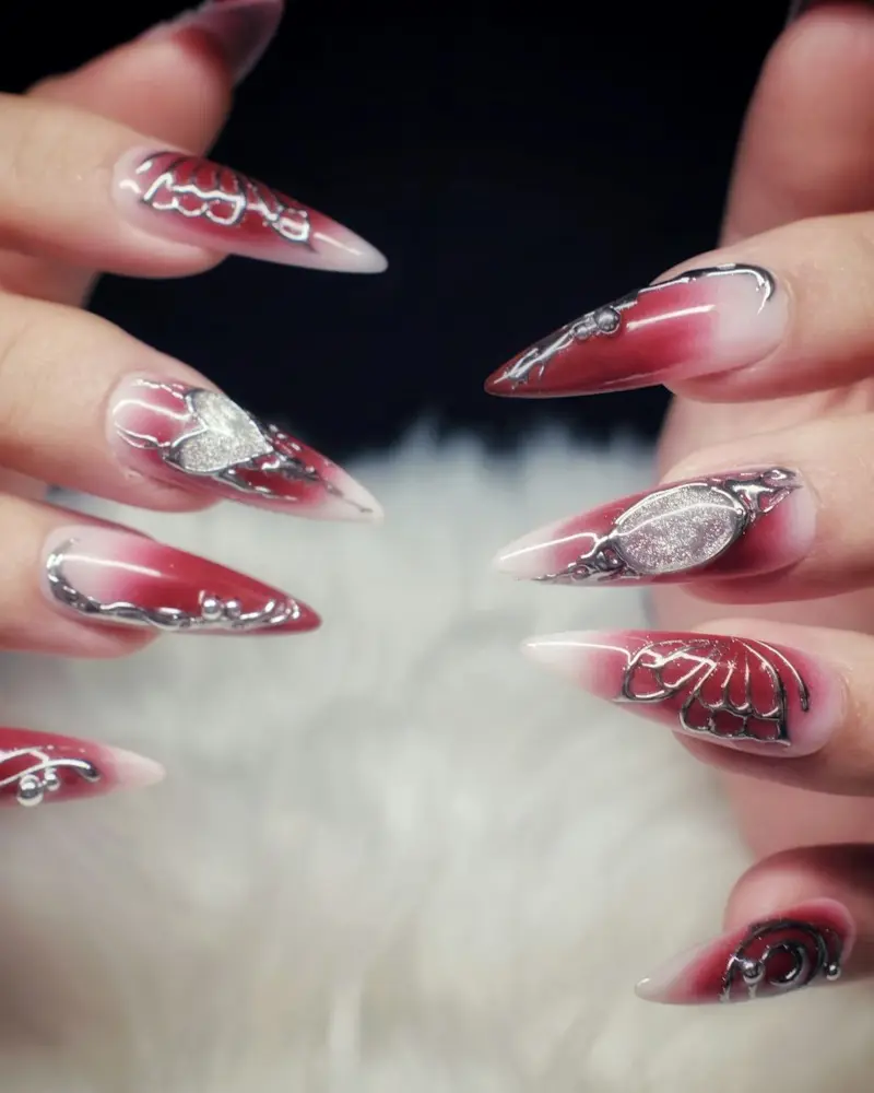 Long stiletto nails in red fading to white with hand-painted swirls