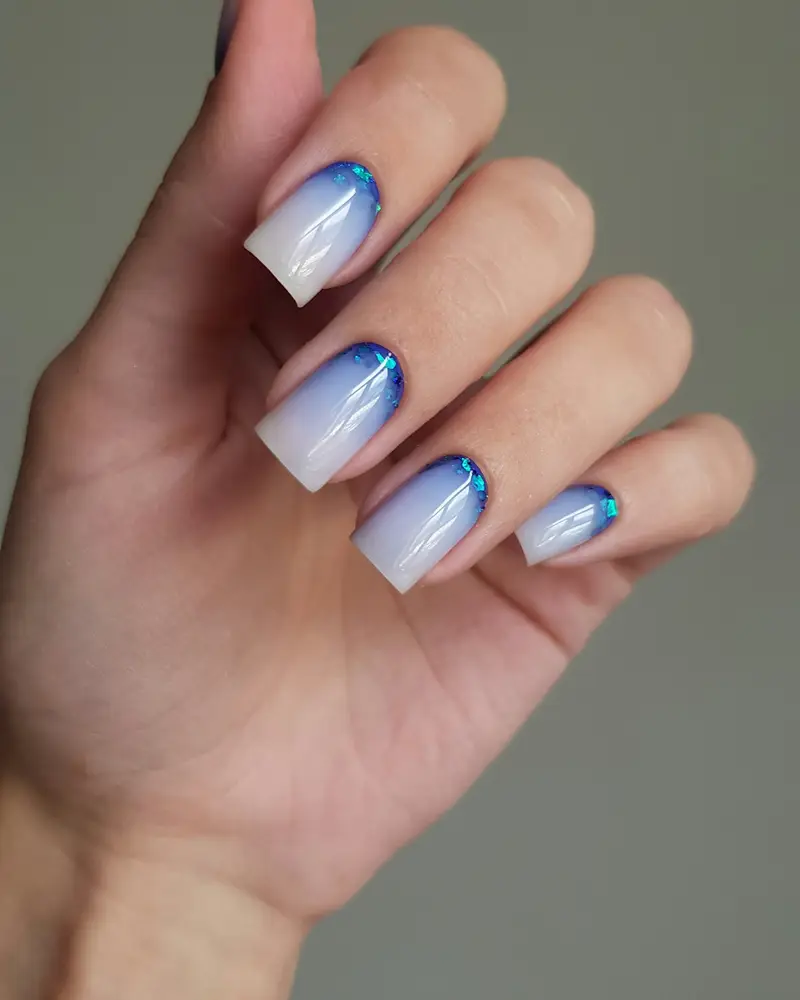 Almond nails fading from white to sky blue at the tip