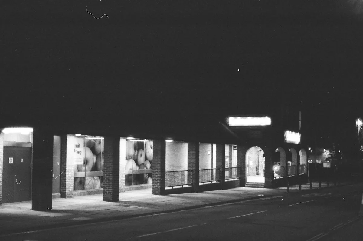 A shop front at night with its windows lit