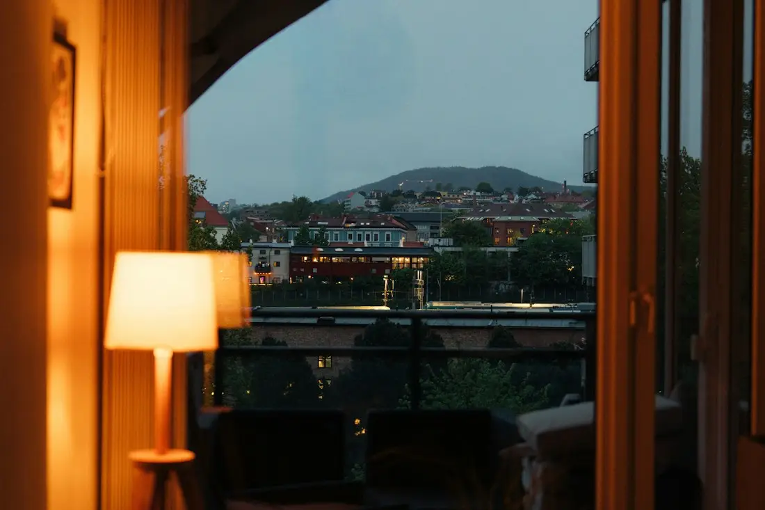 A warm table lamp by a window at dusk